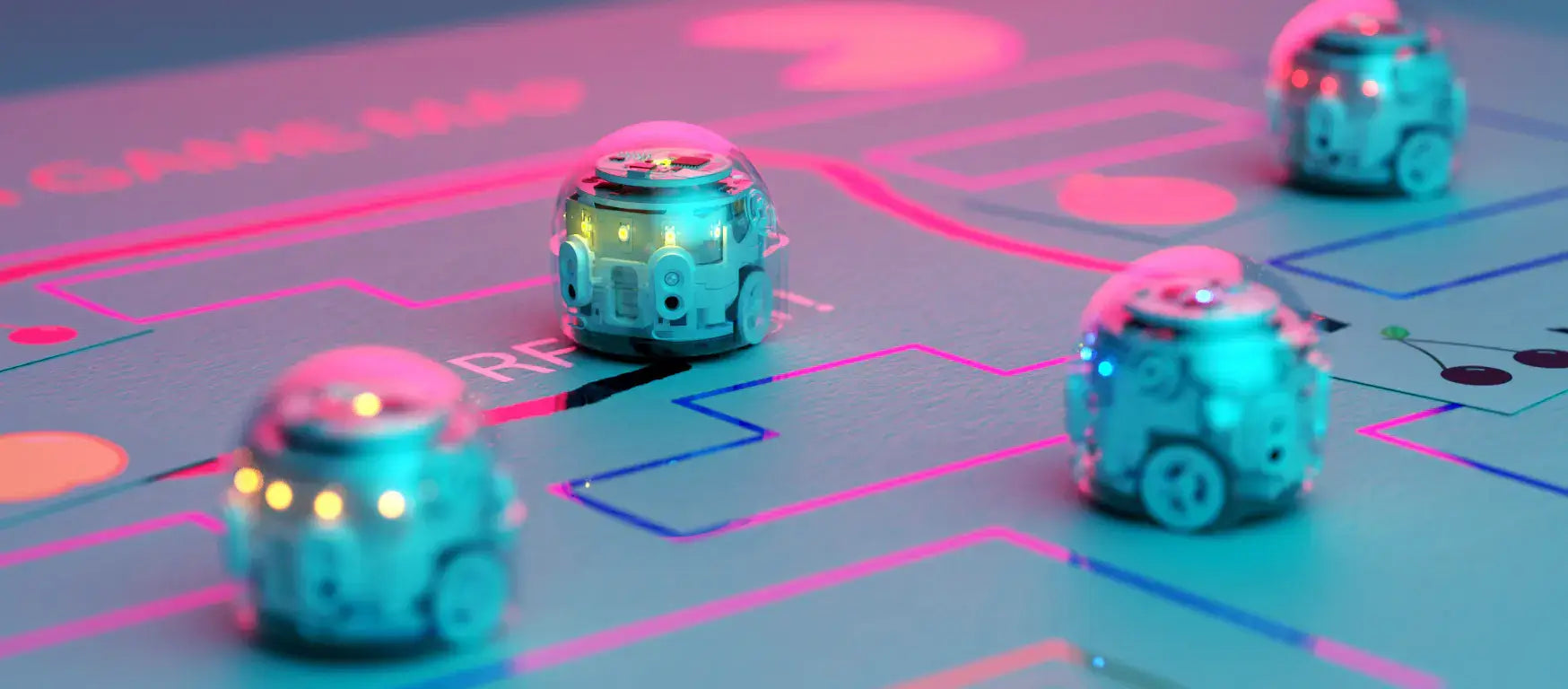 Colorful Ozobots navigating a vibrant coding game map in a classroom setting.