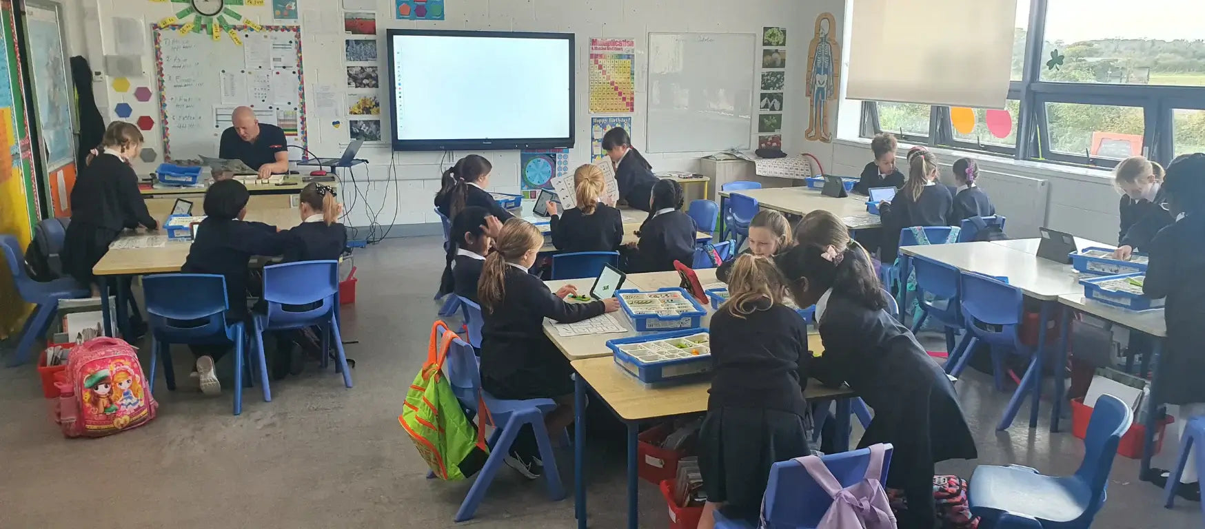 Group of students engaged in a workshop with tablets in a classroom during CreativeHUT Ireland's educational program.