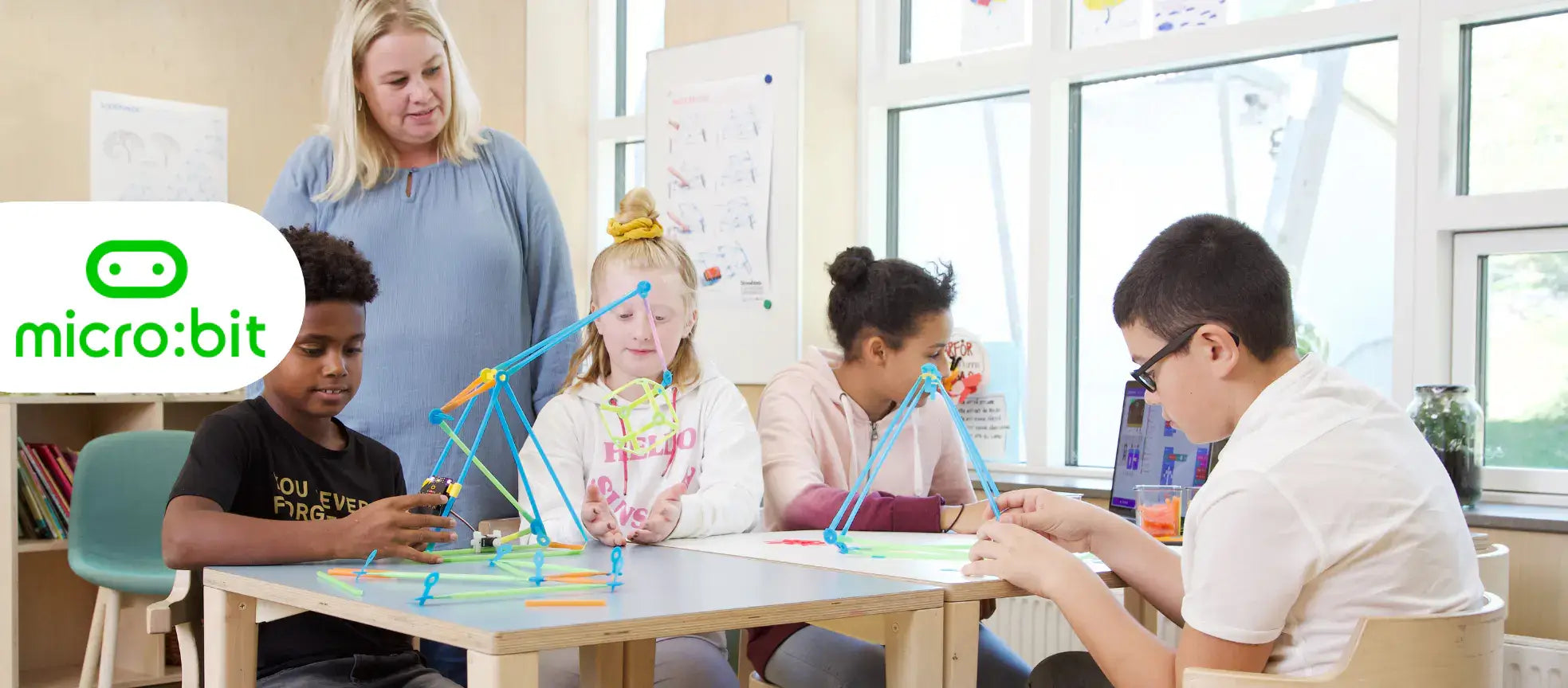 Students engaged in hands-on learning with Micro:bit and Strawbees, fostering creativity and coding skills.