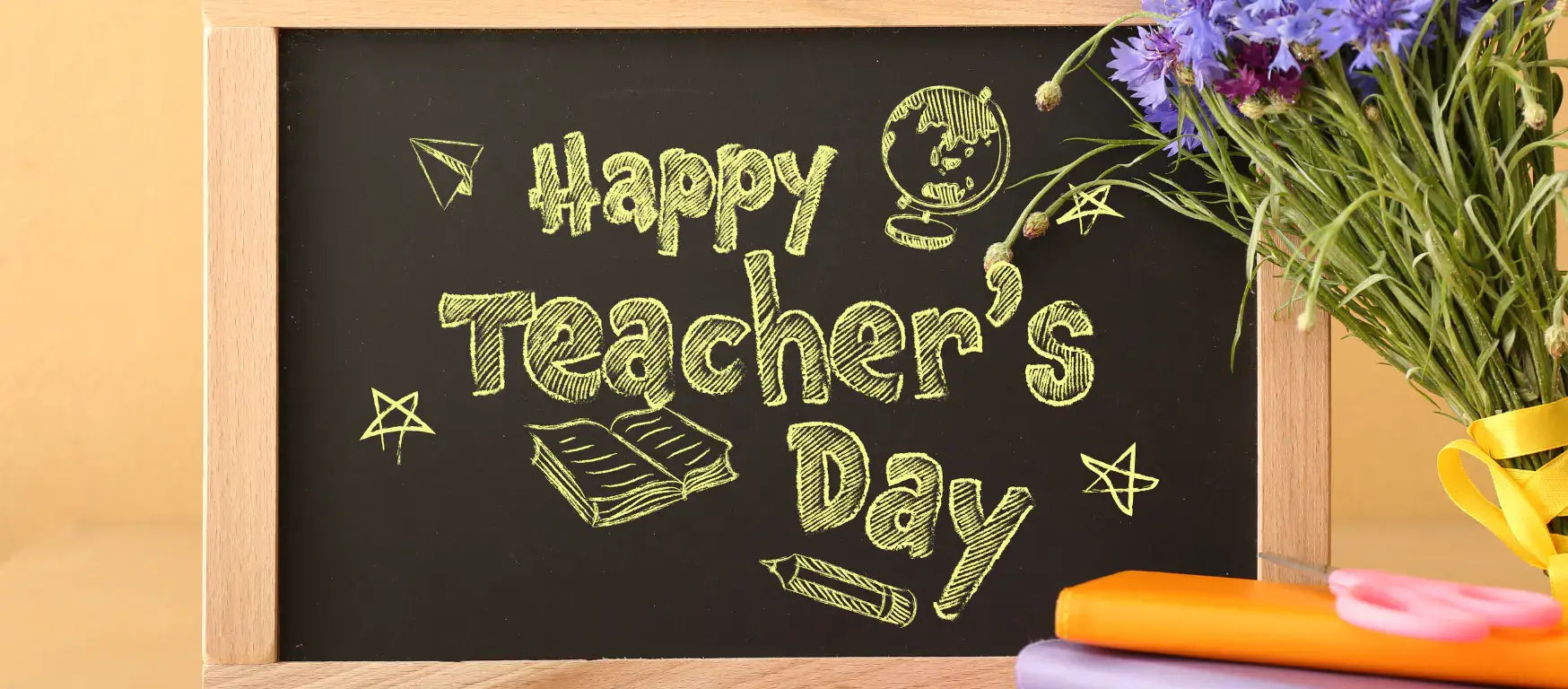Chalkboard displaying 'Happy Teacher's Day' with decorations and a bouquet of flowers.