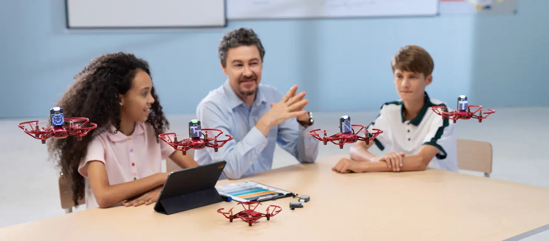 Teacher explaining drones to students in a classroom, enhancing STEM education and coding skills.