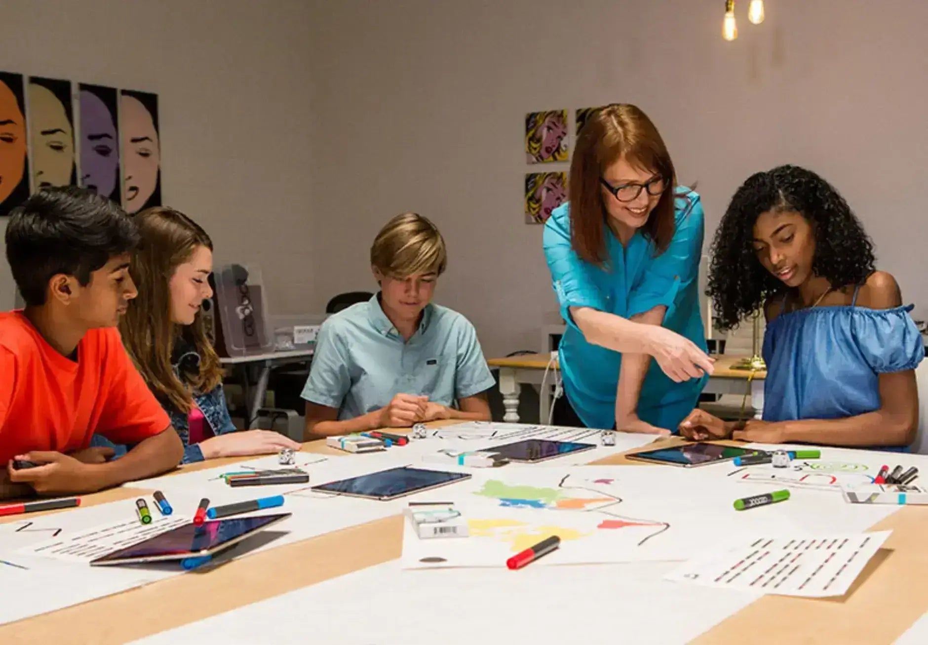 Students engaging in creative art activities with a teacher in a collaborative classroom setting.