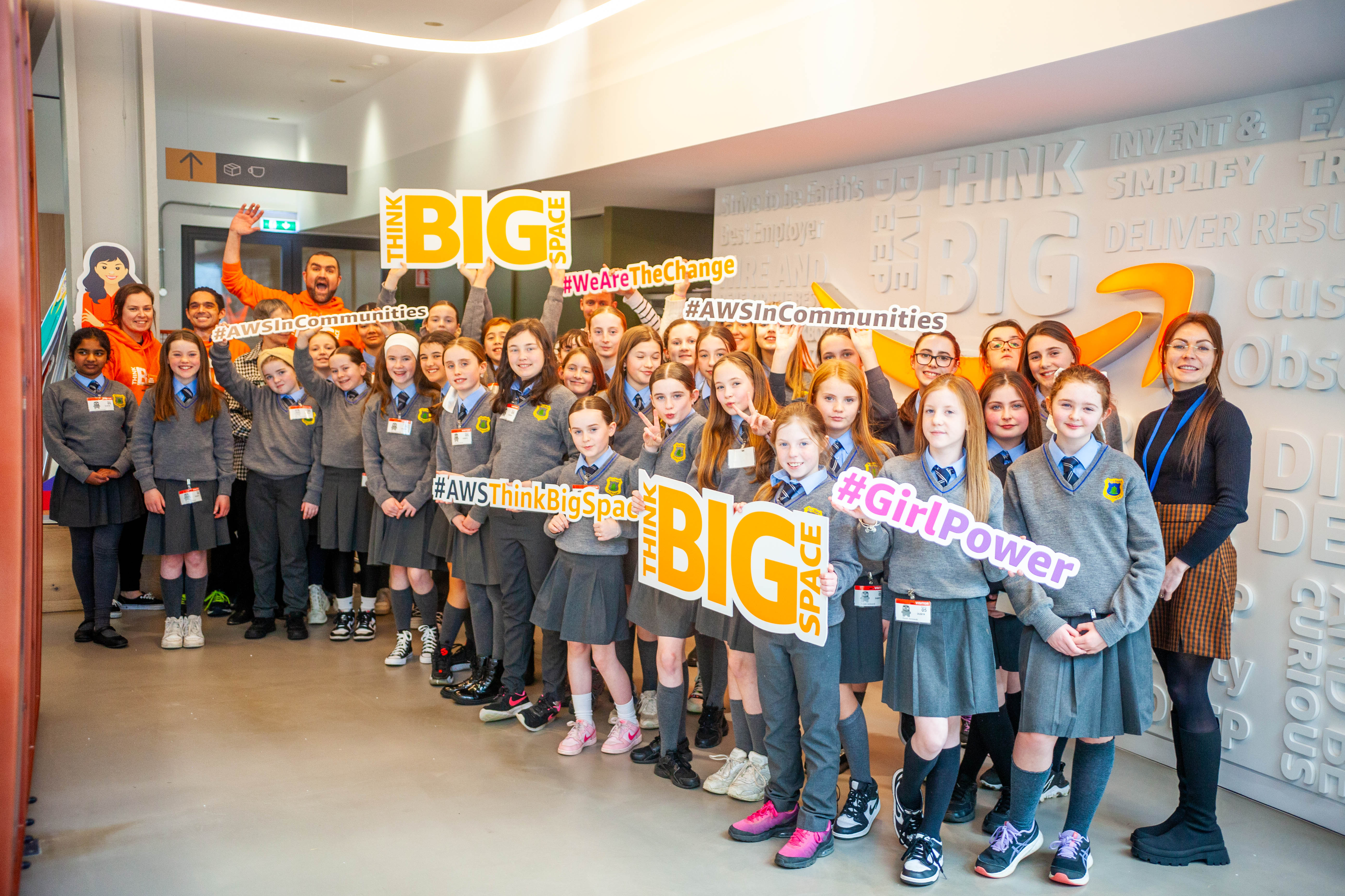 Group of girls at an event promoting empowerment and community engagement with signs about girl power and thinking big.