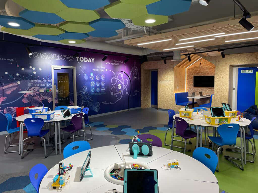 Modern classroom setup with colorful chairs, educational tools, and vibrant wall art promoting innovation and potential.