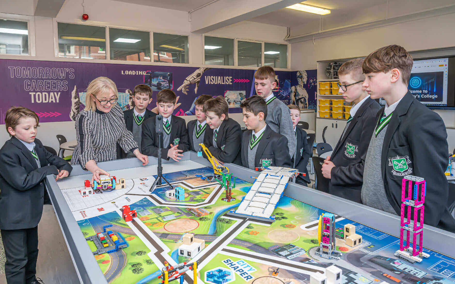 Students engage with a robotics demonstration, guided by a teacher, at a tech learning center.