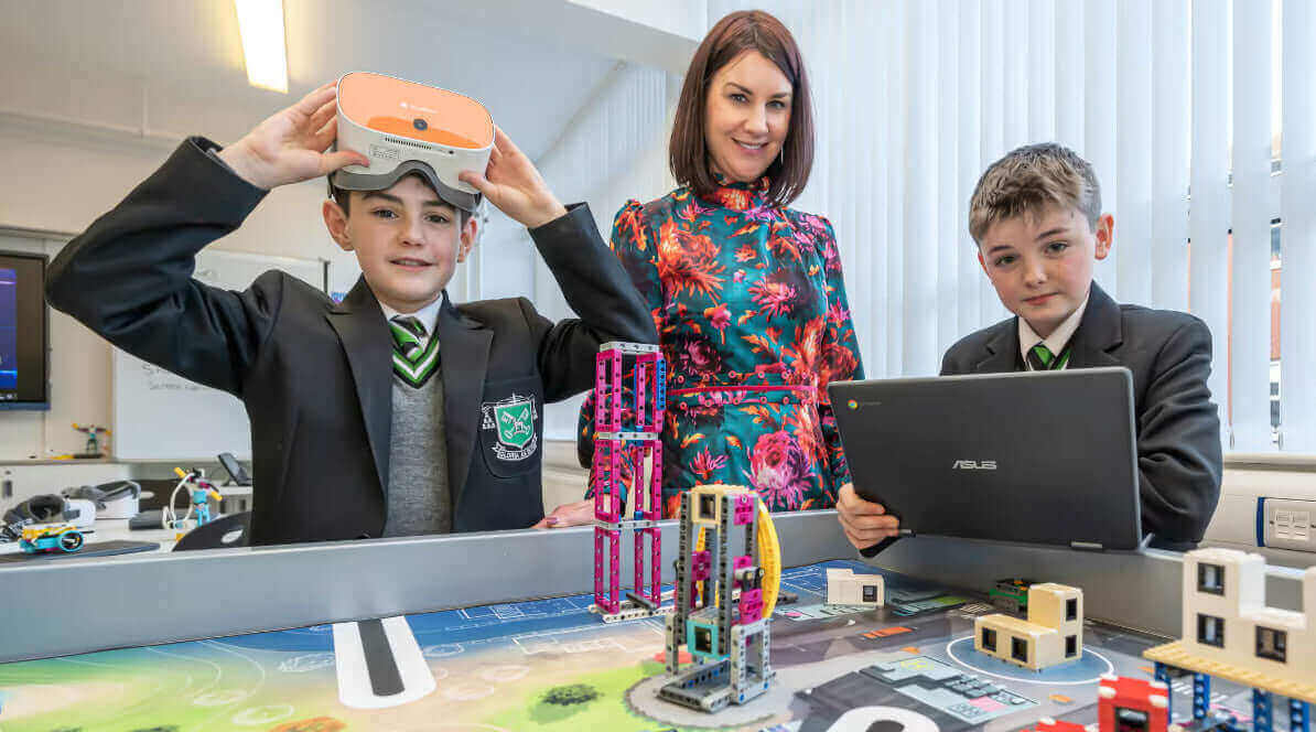 Students using VR technology and a laptop in a classroom, showcasing innovative learning and engagement.