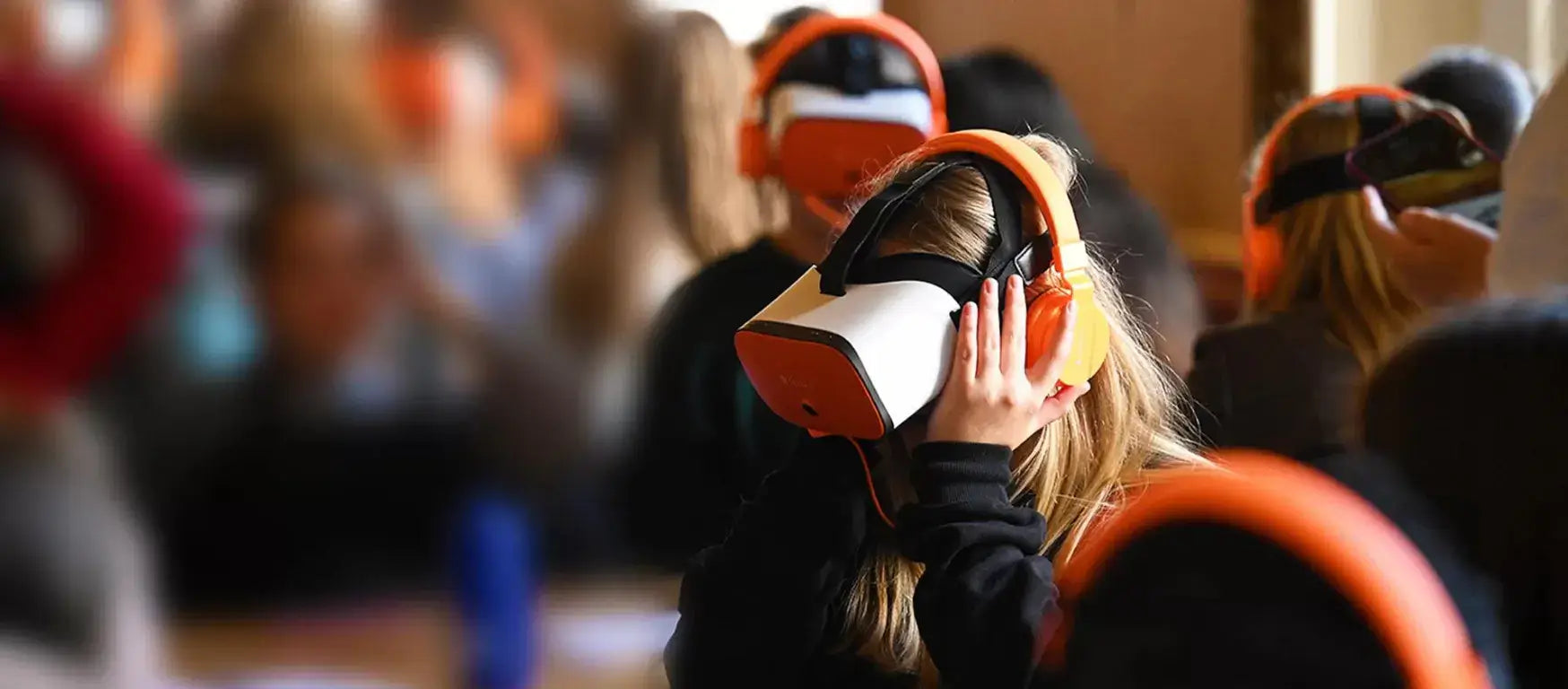 Students engaged in virtual reality learning with headsets in a classroom setting.