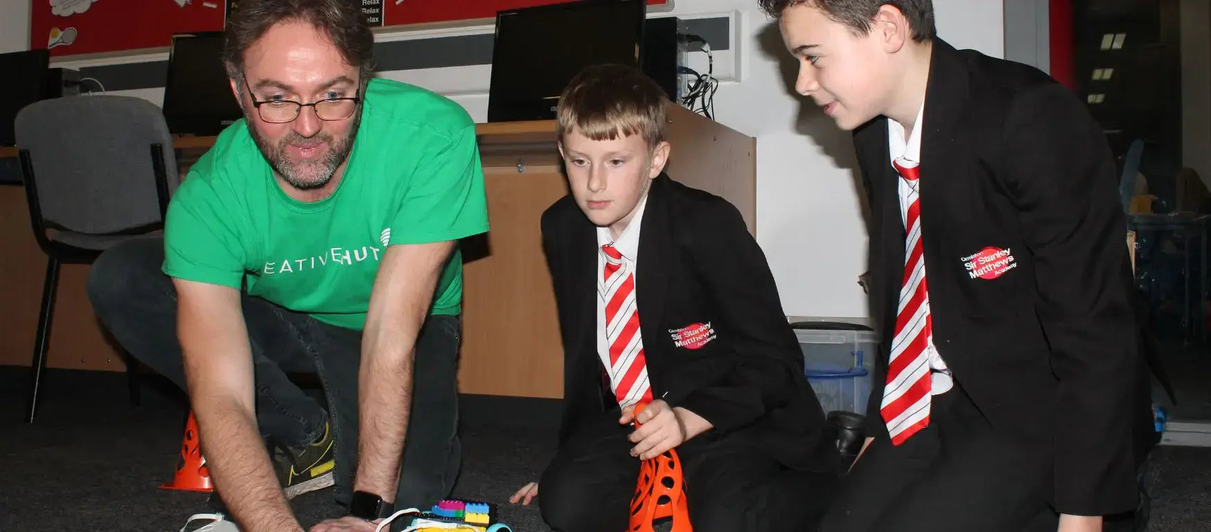 Instructor demonstrating robotics to students during Ormiston Academy's STEAM workshop, fostering hands-on learning.