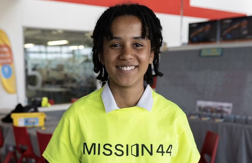 Smiling individual wearing a bright yellow Mission44 shirt, promoting community engagement and support.