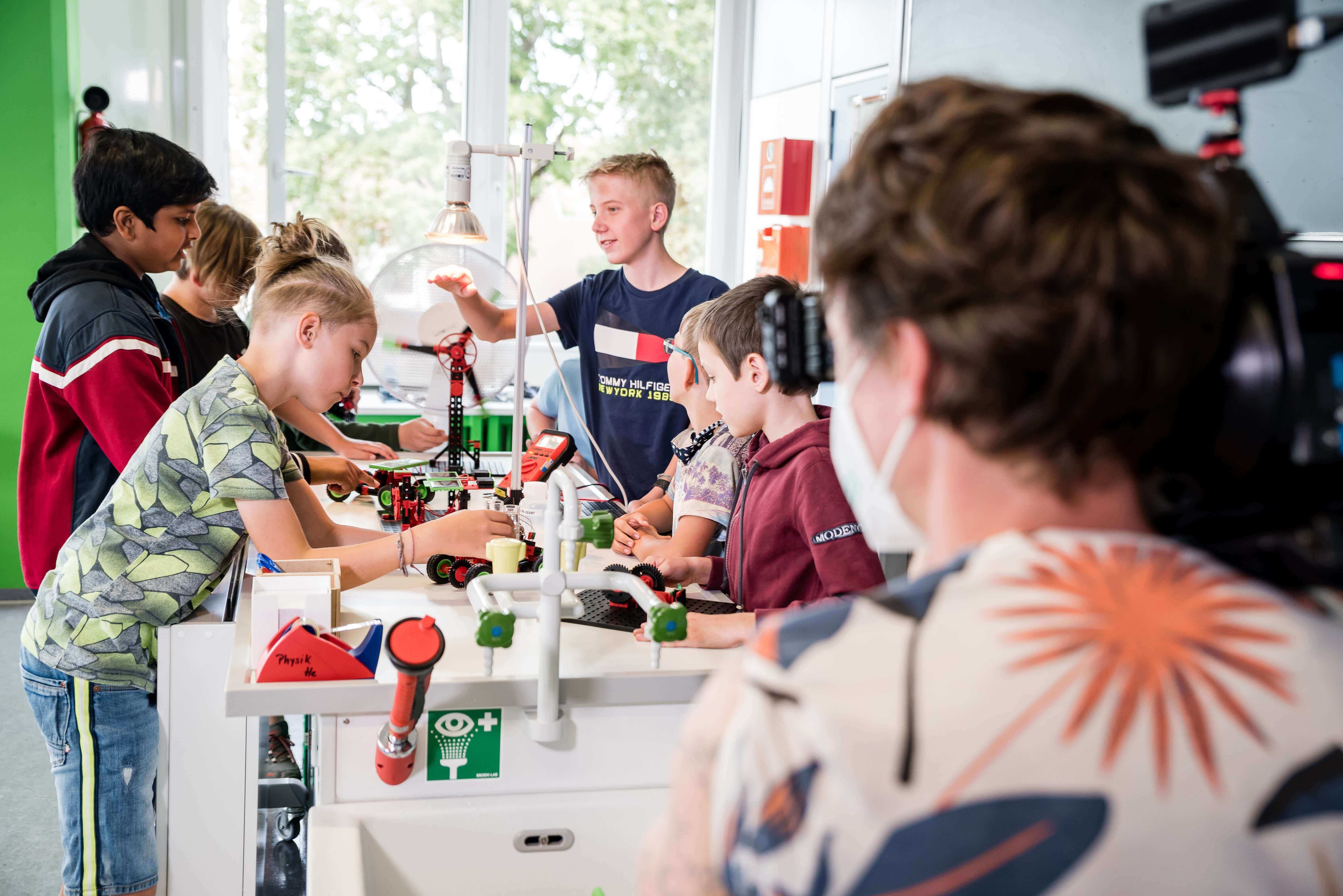 Children engaged in hands-on STEM activities in a classroom, collaborating and experimenting together.