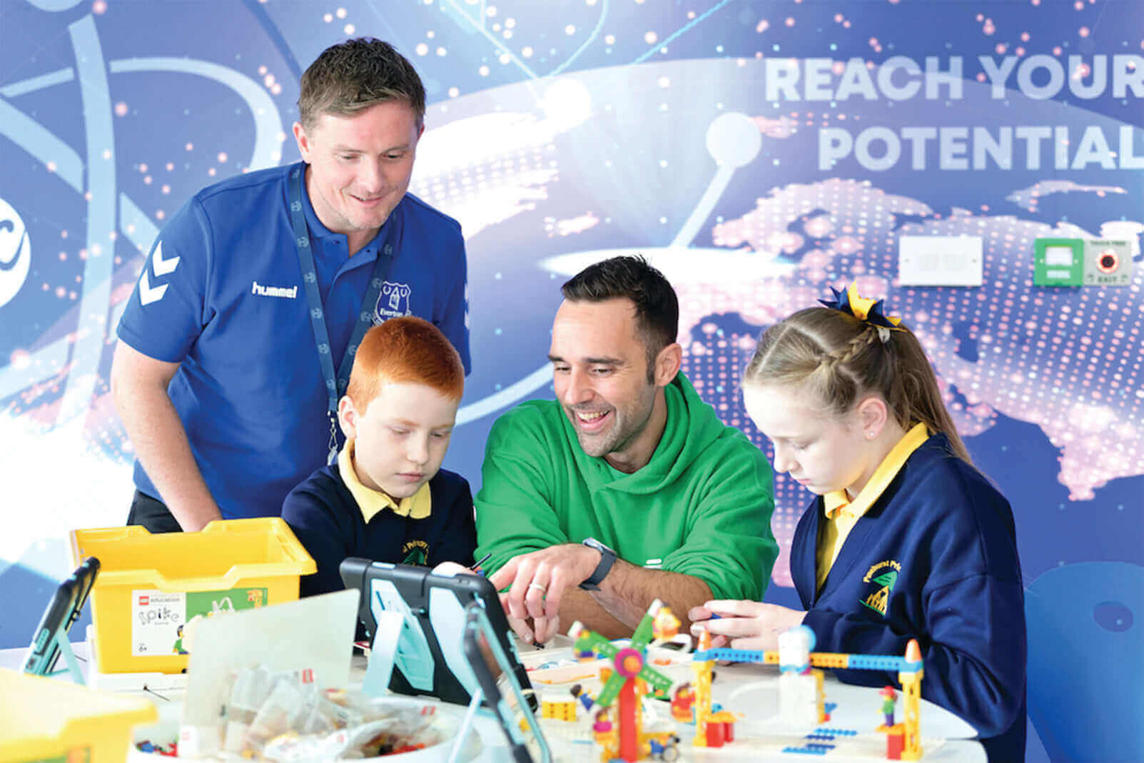 Children learning and engaging with mentors in a creative workshop, showcasing teamwork and innovation.