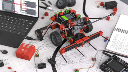 STEM Coding RoboMission robotics construction kit on a workspace with laptop and design schematics.