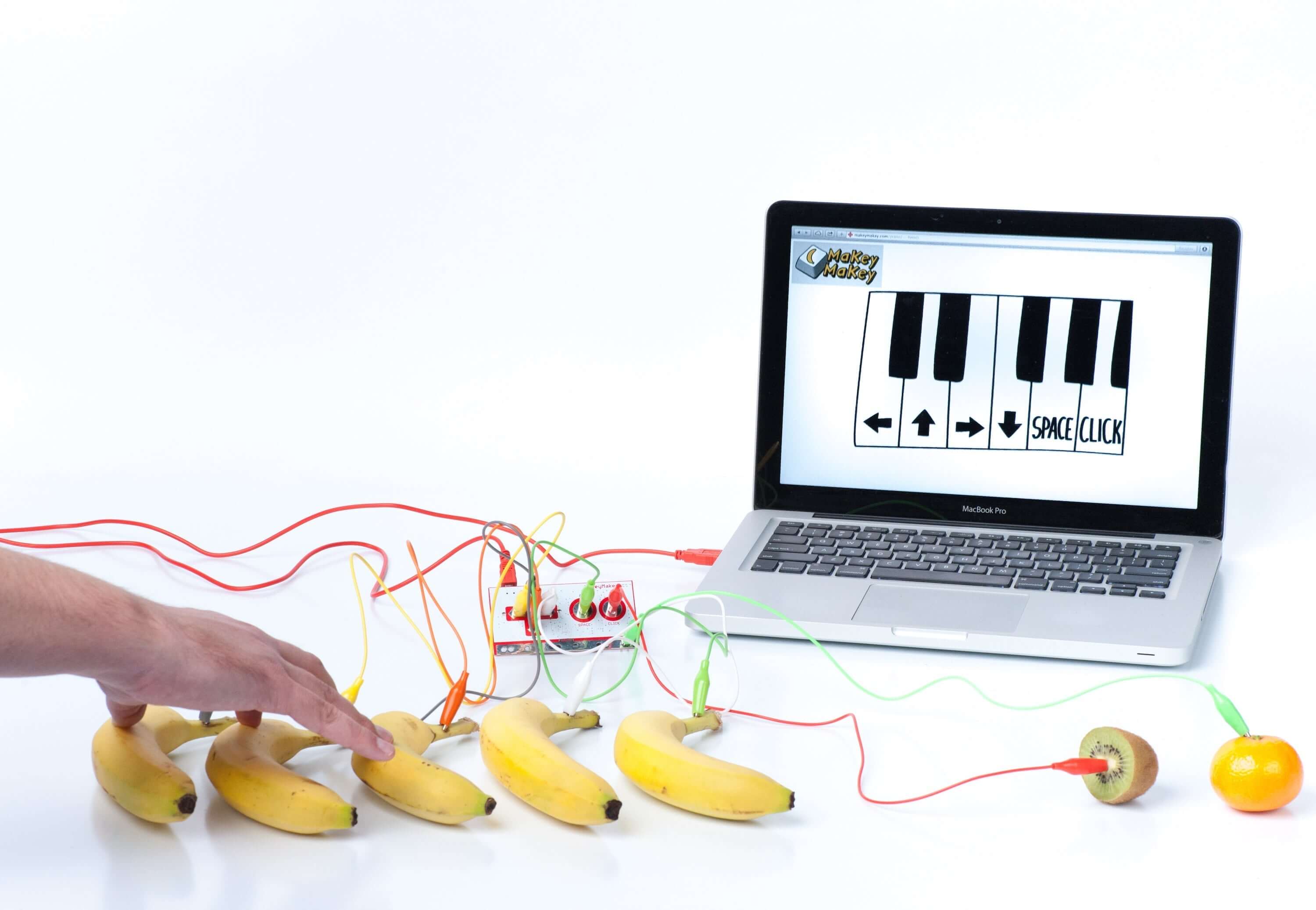 Makey Makey® setup with bananas as piano keys connected to a laptop for creative invention.