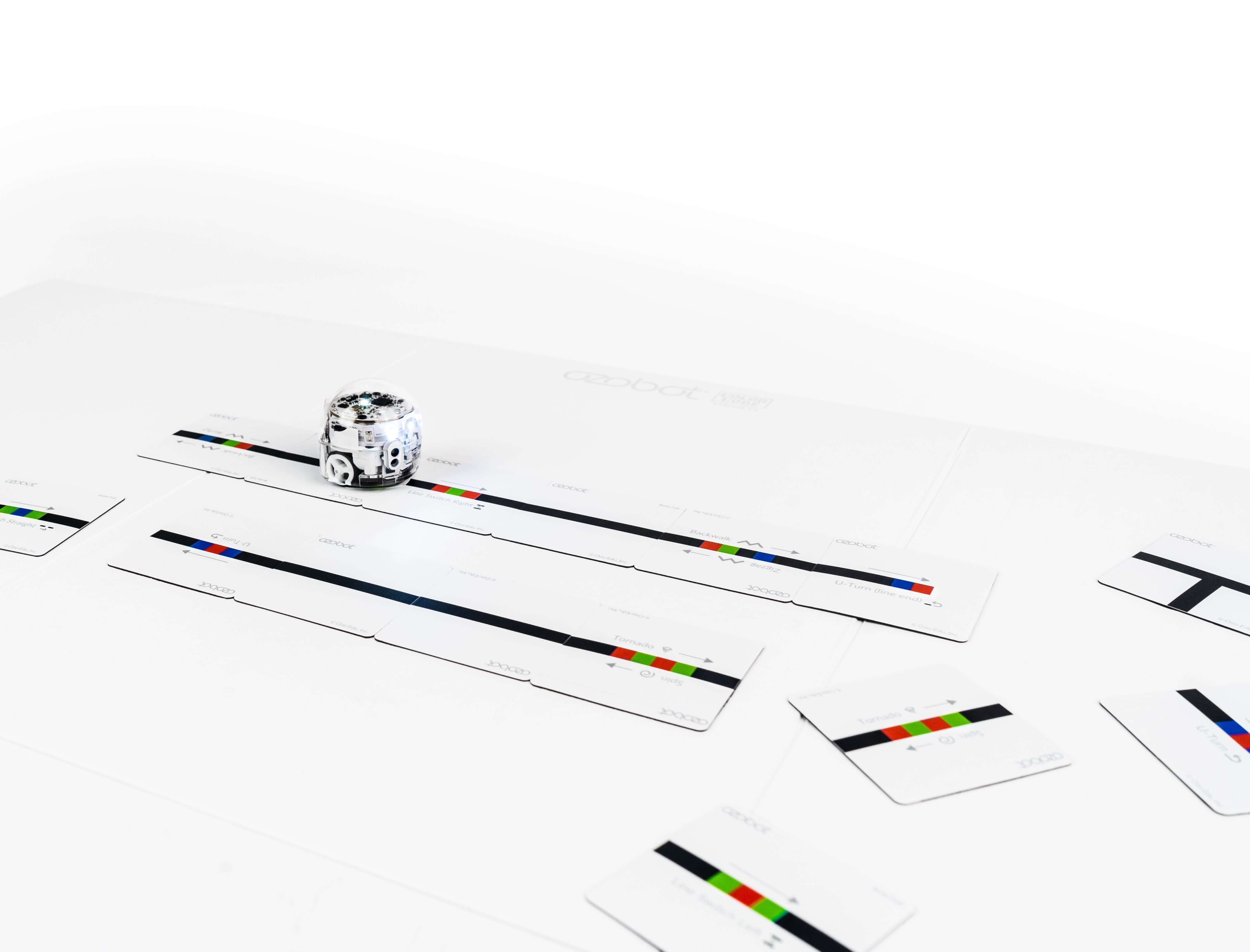 Ozobot Colour Code Magnets with coding puzzle pieces, showcasing an Evo robot on a learning board.