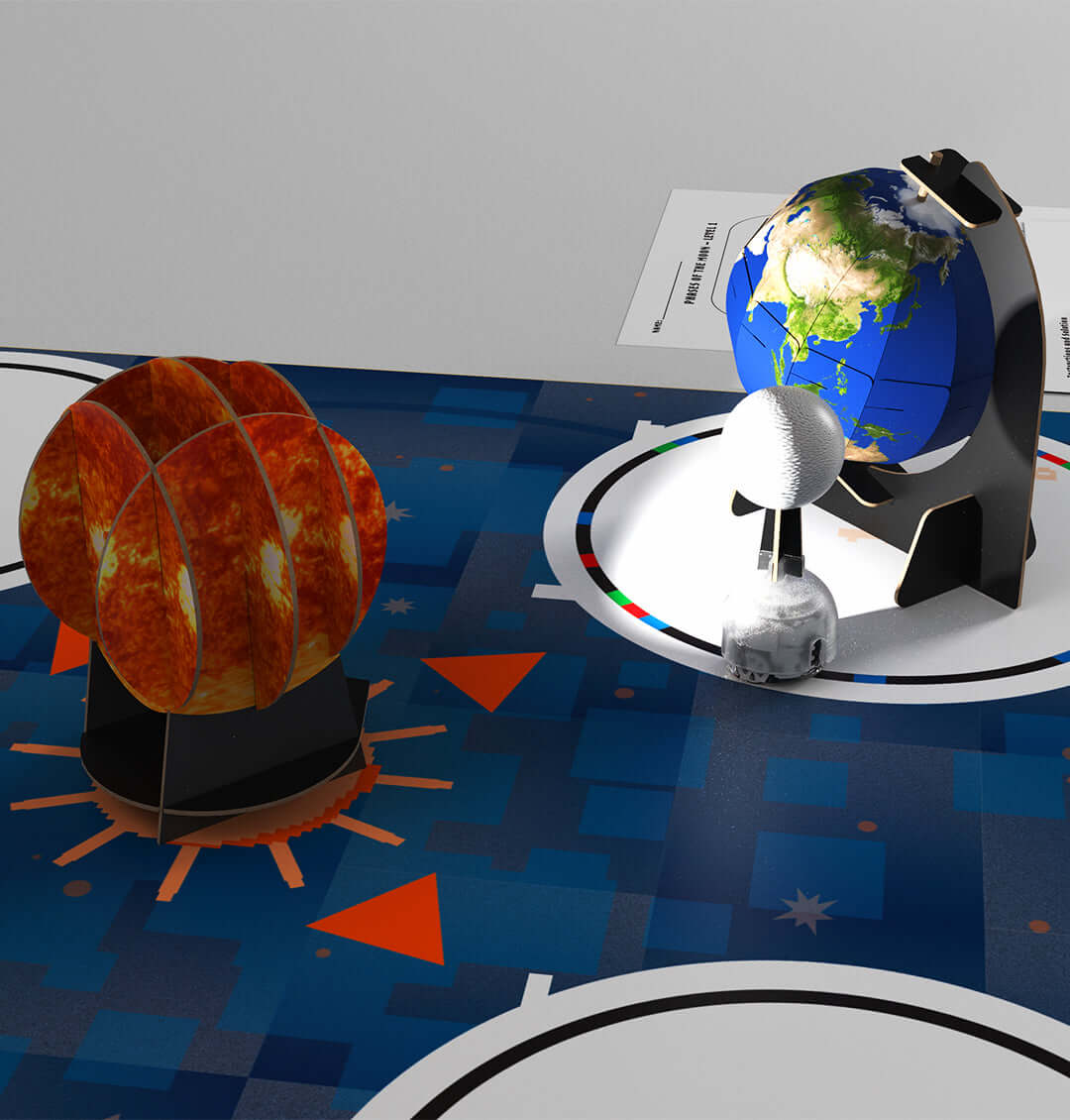 Colorful models of the Sun, Earth, and Moon on a STEAM activity mat for educational exploration.