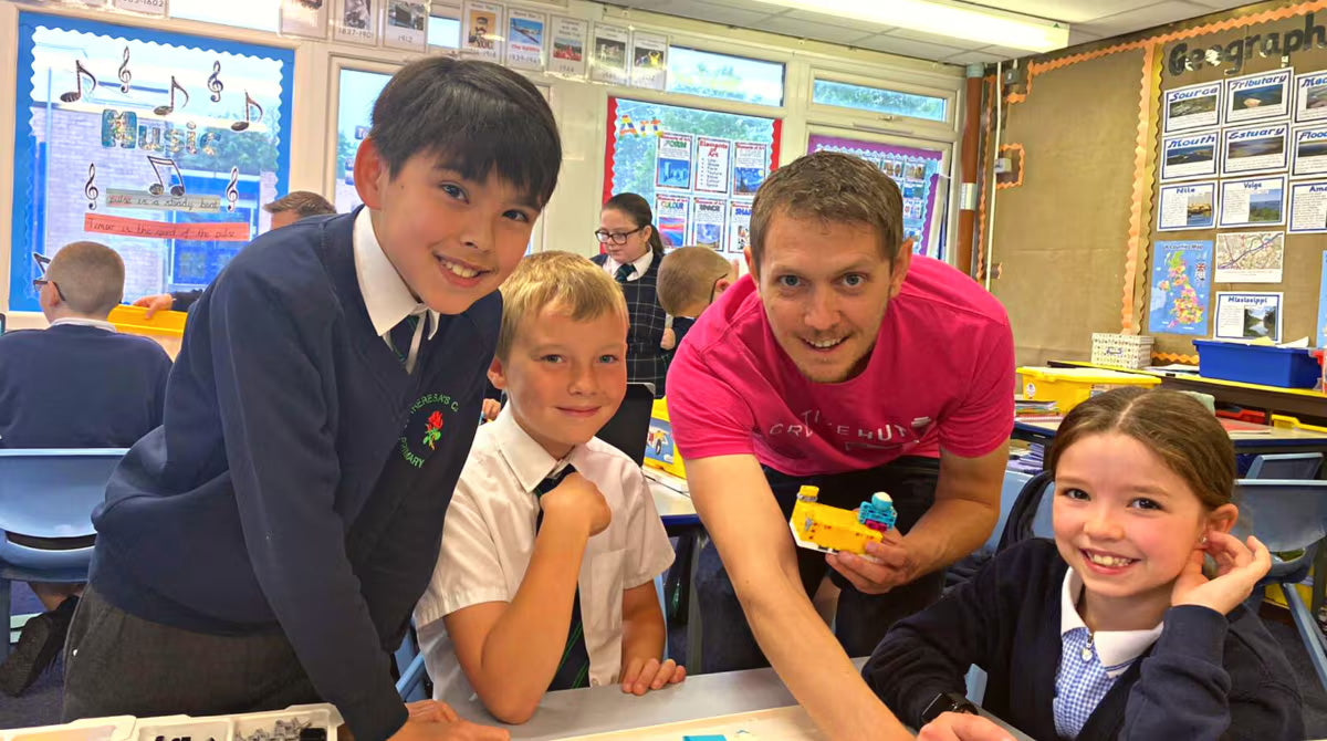 Students engaged in a classroom activity with a teacher, showcasing learning and teamwork.